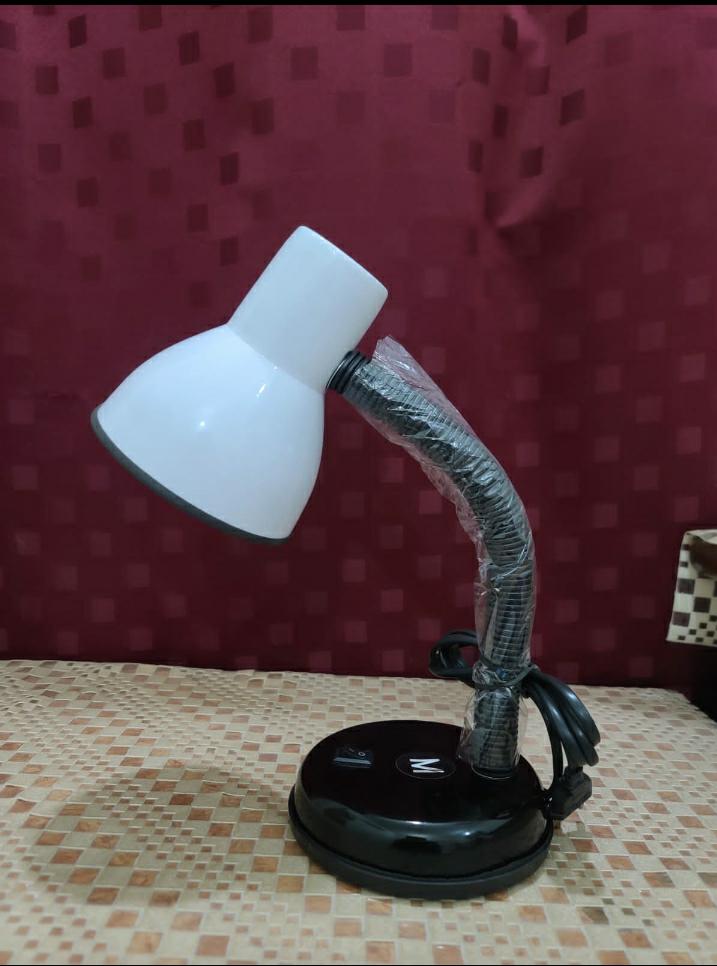 White desk lamp with flexible neck on a patterned surface