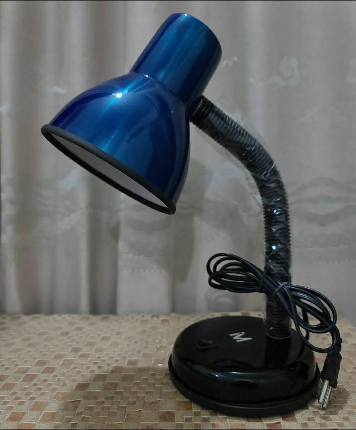 Blue desk lamp with flexible neck on a textured surface